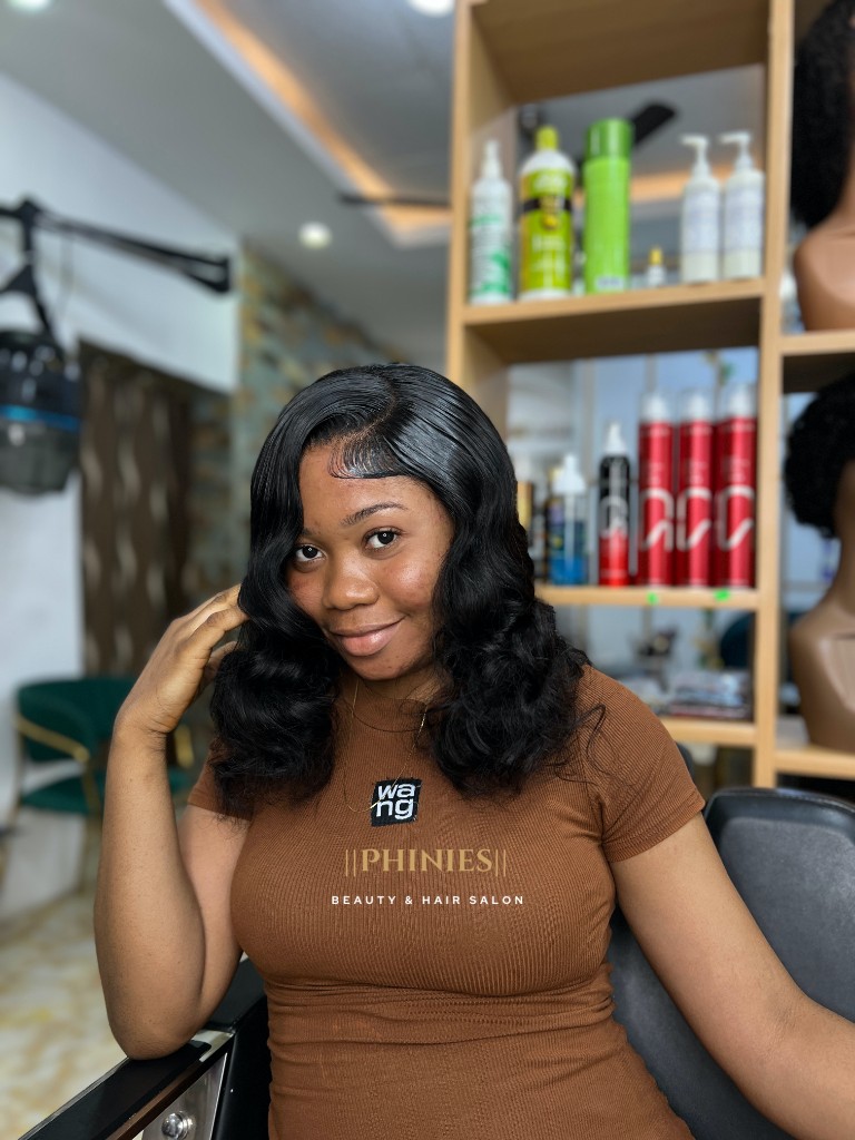 Client wearing a styled closure wig in the salon